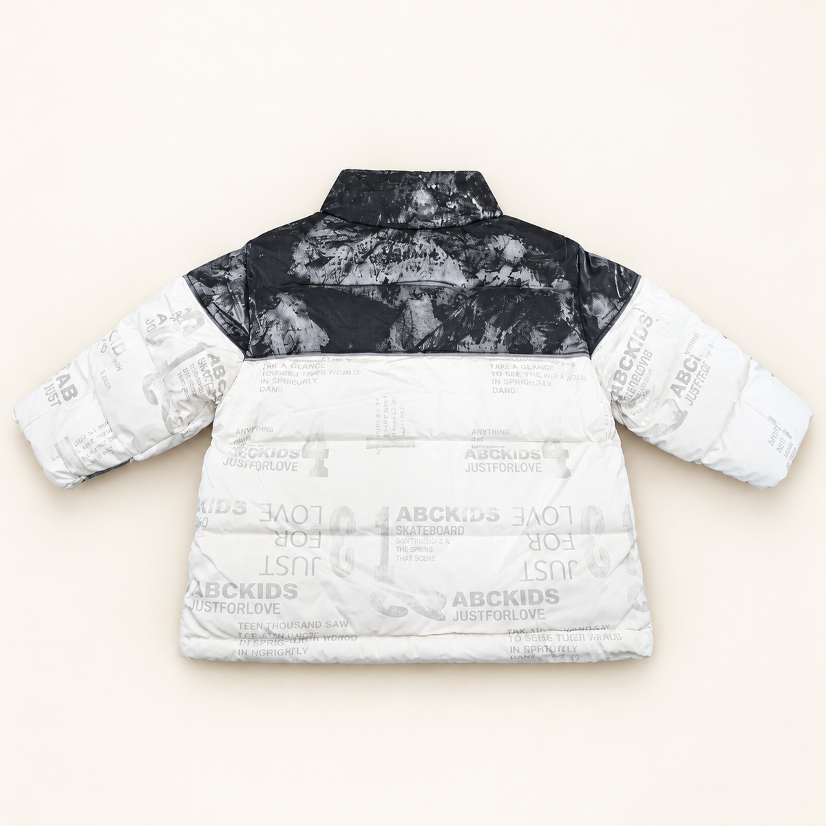 Back view of Monochrome Puffer Jacket with charcoal shoulder panel and white printed padded body