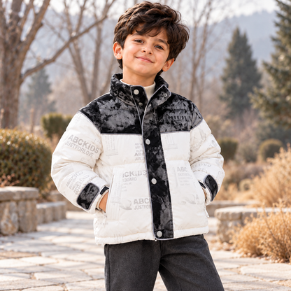 Boy wearing the Monochrome Puffer Jacket on a stone path in a winter garden