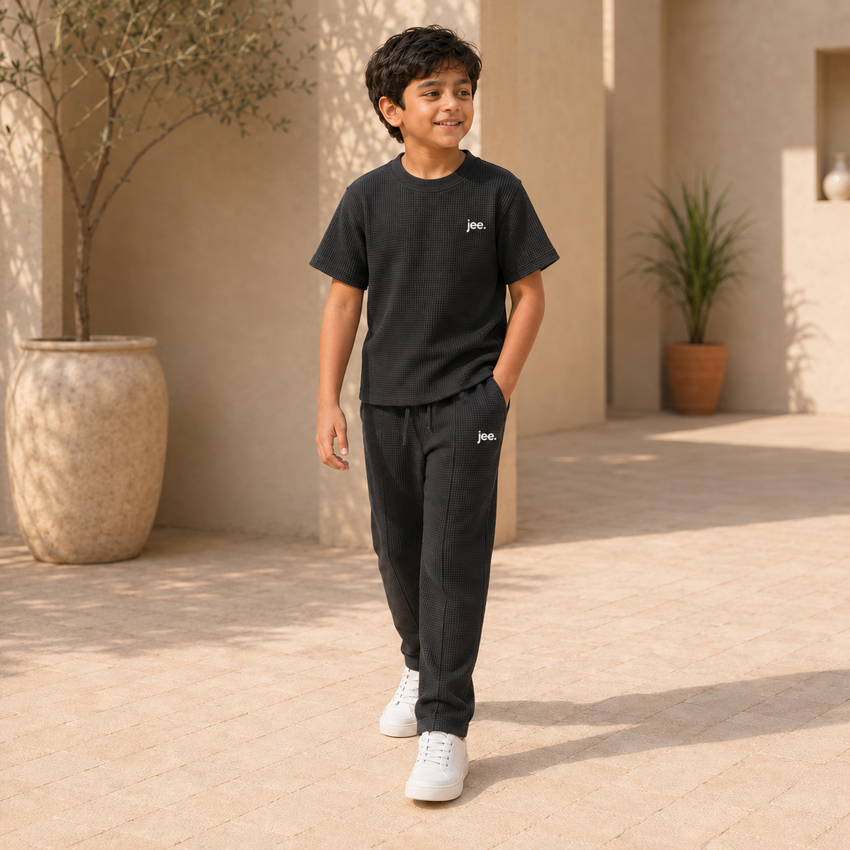 Older boy wearing Black Round Neck cord set with jee. logo